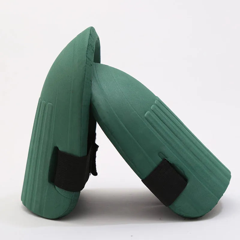 A pair of rectangular EVA foam knee pads in army green colour, shown on a garden soil background.