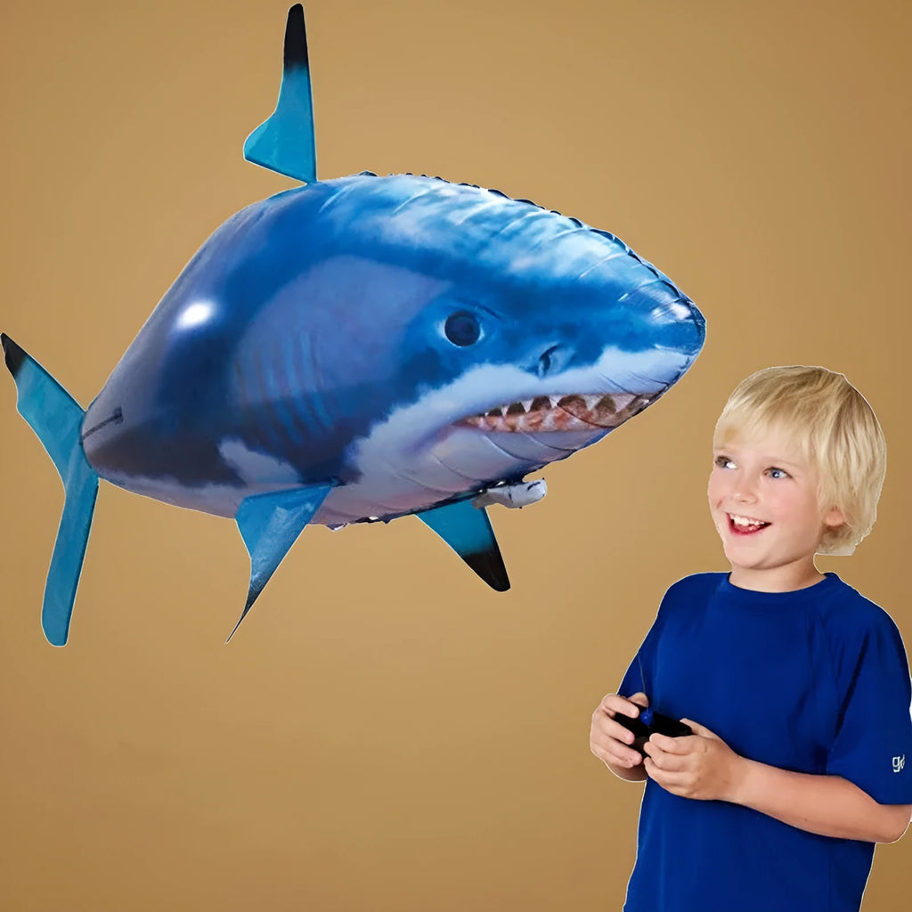 Large remote control inflatable shark balloon floating indoors with remote.