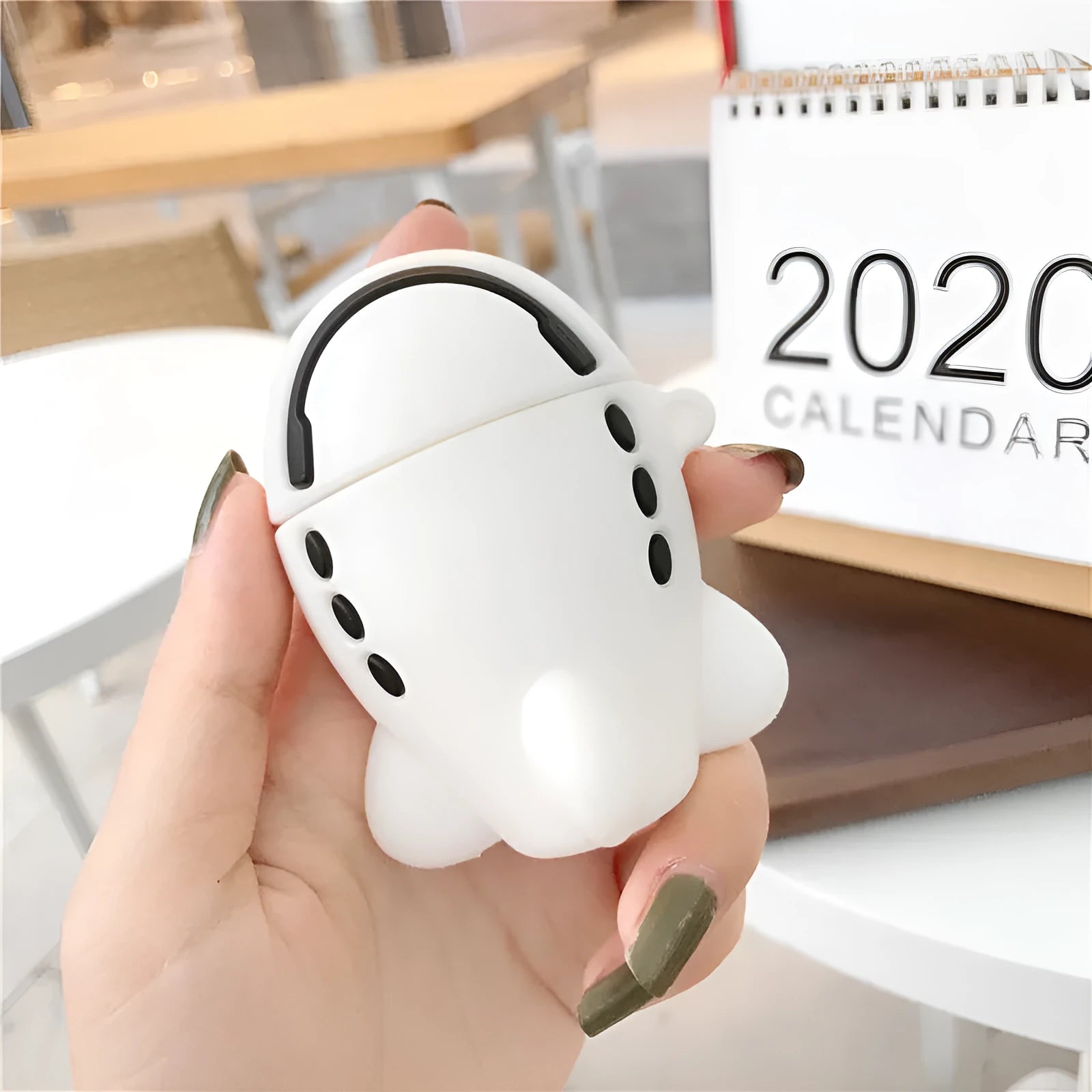 Silicone AirPods protective case with flip-top design, cartoon airplane graphics, and integrated carrying hook
