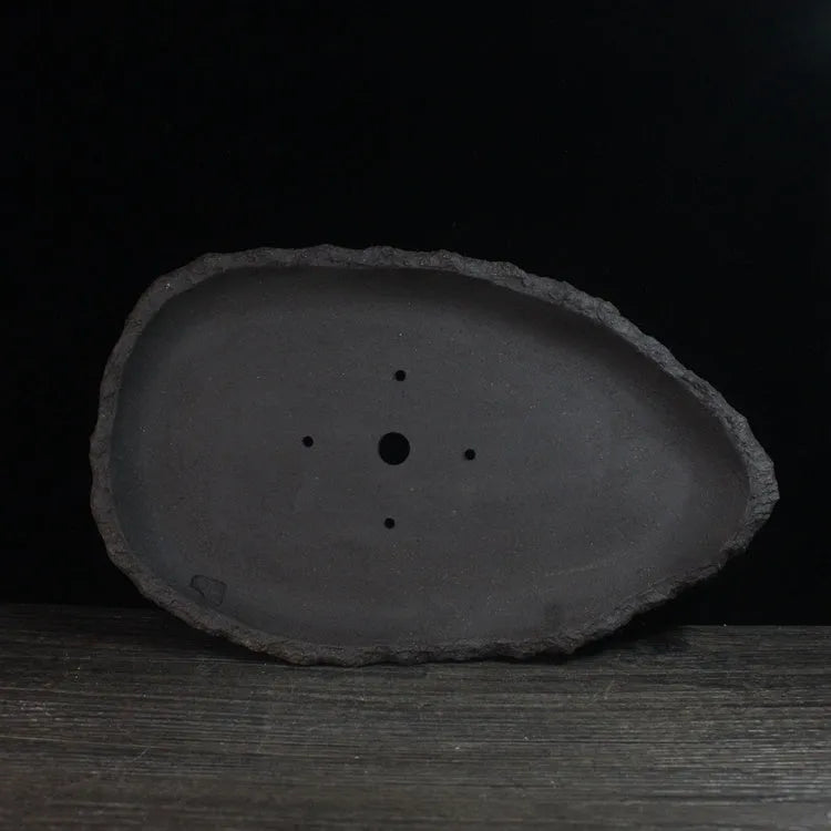 Handmade purple clay flower pot showing unique shape and traditional ceramic texture