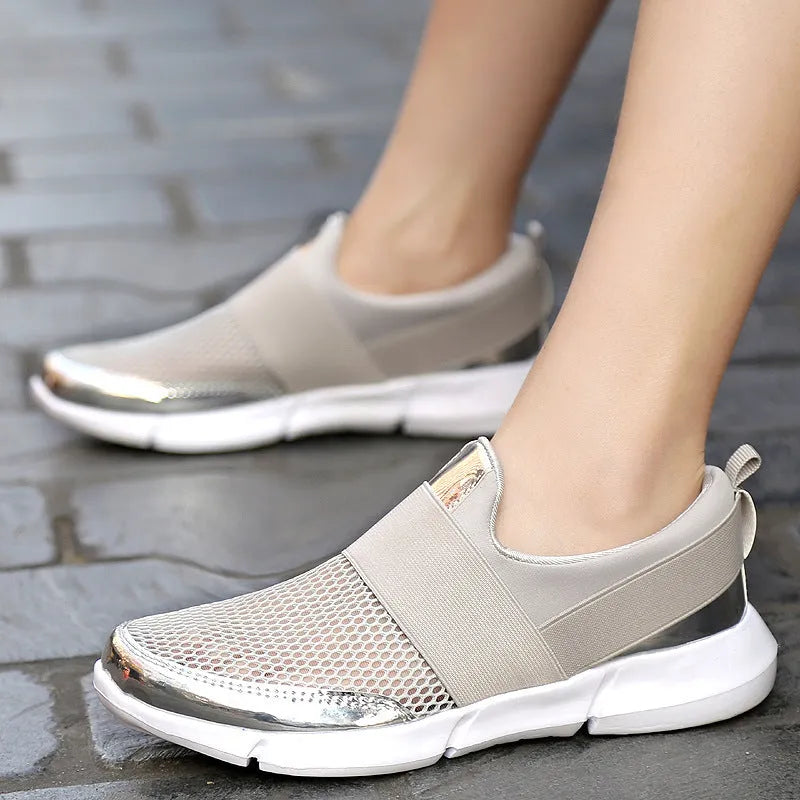Women's blue, black, and grey lightweight mesh low-top sneakers on a hard floor.