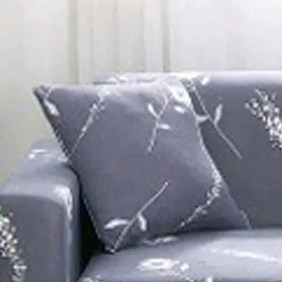 Geometric abstract printed stretch sofa slipcover covering a three-seater sofa with matching cushion covers.
