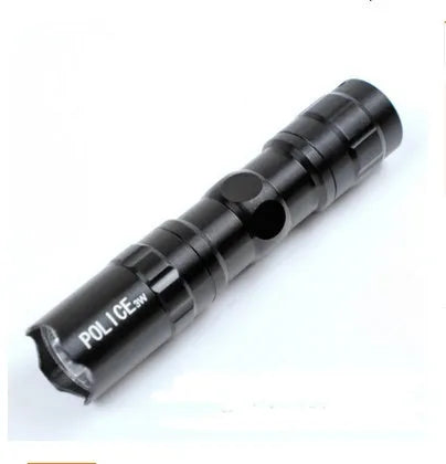 Small black aluminium LED flashlight with a strong beam, shown next to a AA battery for scale.