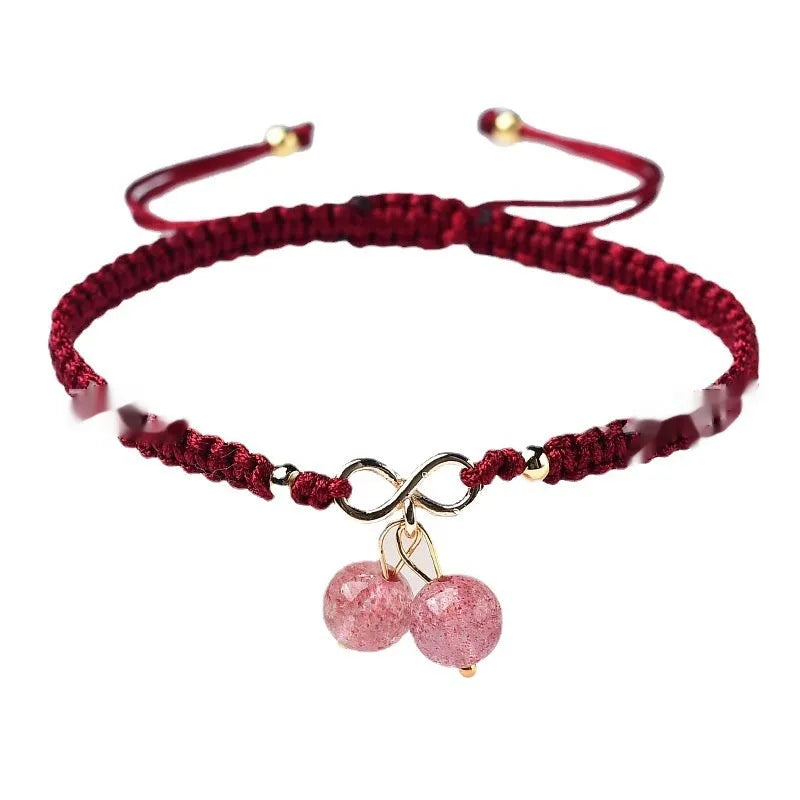 Women's natural strawberry quartz bracelet with a fruit-shaped crystal charm on wrist.