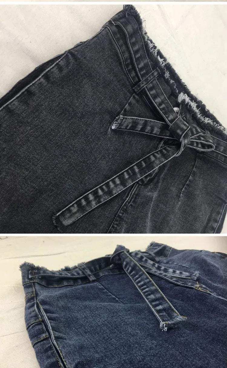 Women's fringed jeans in dark blue denim with frayed hem detailing, size chart displayed
