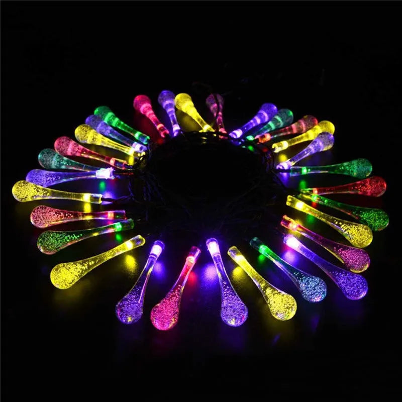 Solar-powered outdoor water drop LED string lights with warm white illumination on 6.5 metre waterproof cord