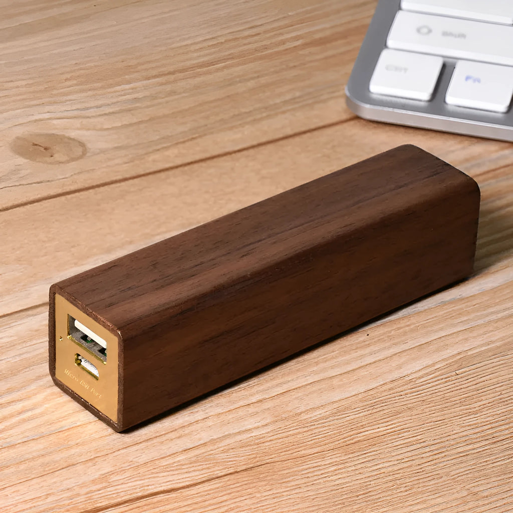 Brown black walnut wood portable power bank showing size next to a charging cable