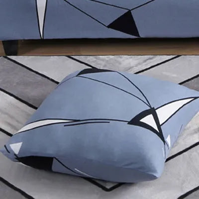 Geometric abstract printed stretch sofa slipcover covering a three-seater sofa with matching cushion covers.