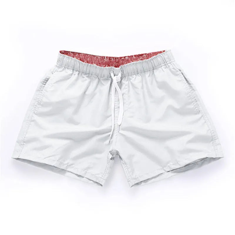 Men's straight-leg beach shorts in polyester fabric shown in a solid colour, laid flat.