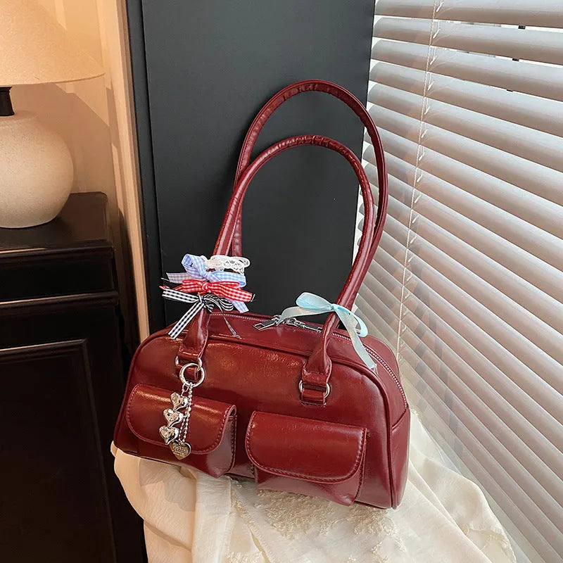 Retro pillow-shaped women's PU leather shoulder bag in black with double straps and flap closure.