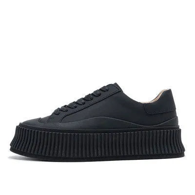 Women's black suede platform shoes with thick soles, back lacing, and a muffin heel on a white background.