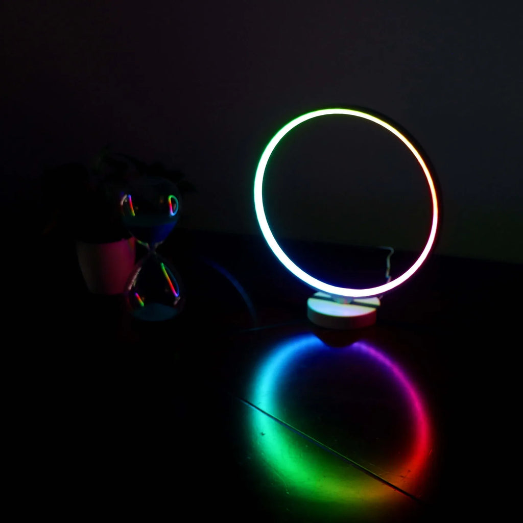 White spherical Full Moon Lamp with remote control on wooden table showing warm white glow