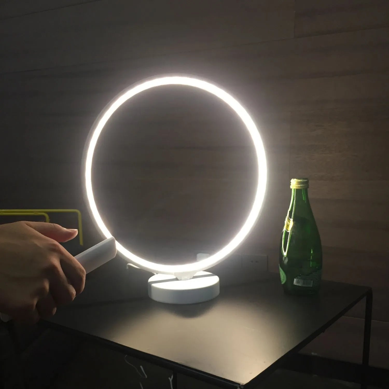 White spherical Full Moon Lamp with remote control on wooden table showing warm white glow