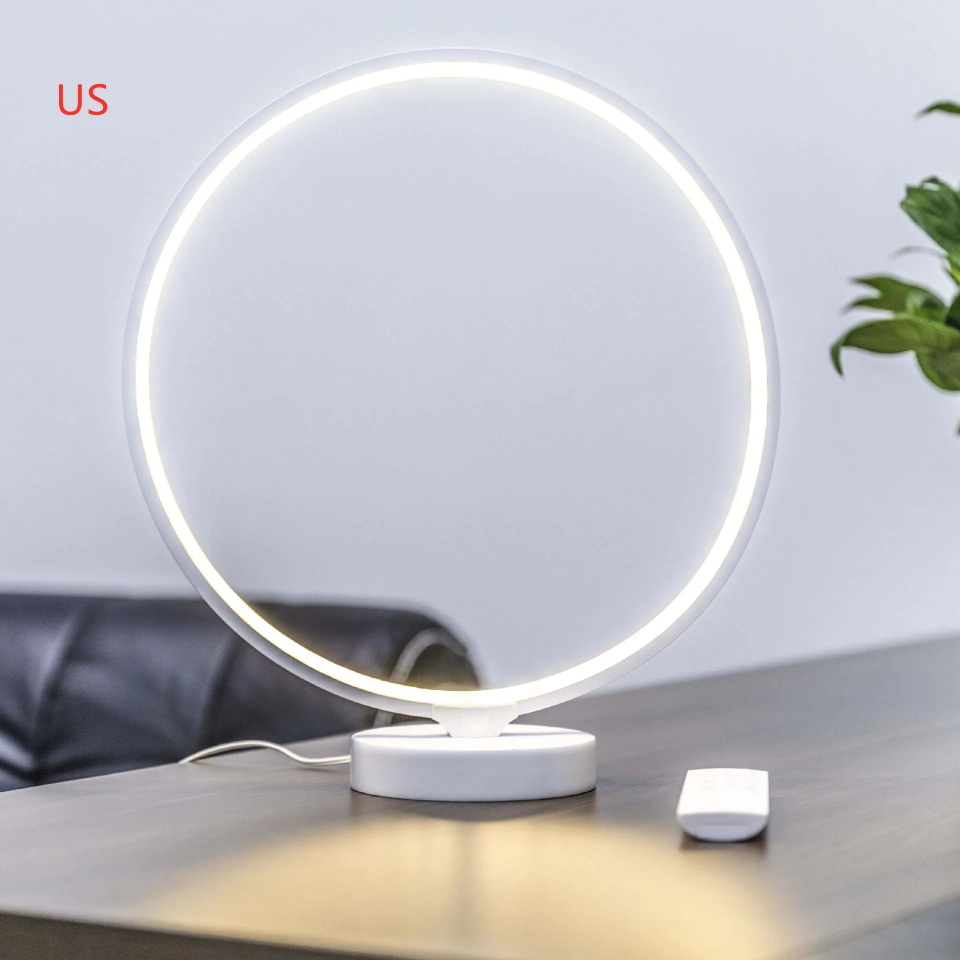White spherical Full Moon Lamp with remote control on wooden table showing warm white glow