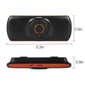 Orange plastic Bluetooth car hands-free speaker mounted on vehicle sun visor