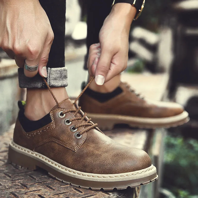Men's black casual shoes with round toe, flat rubber sole, and front lace-up closure on a plain background.