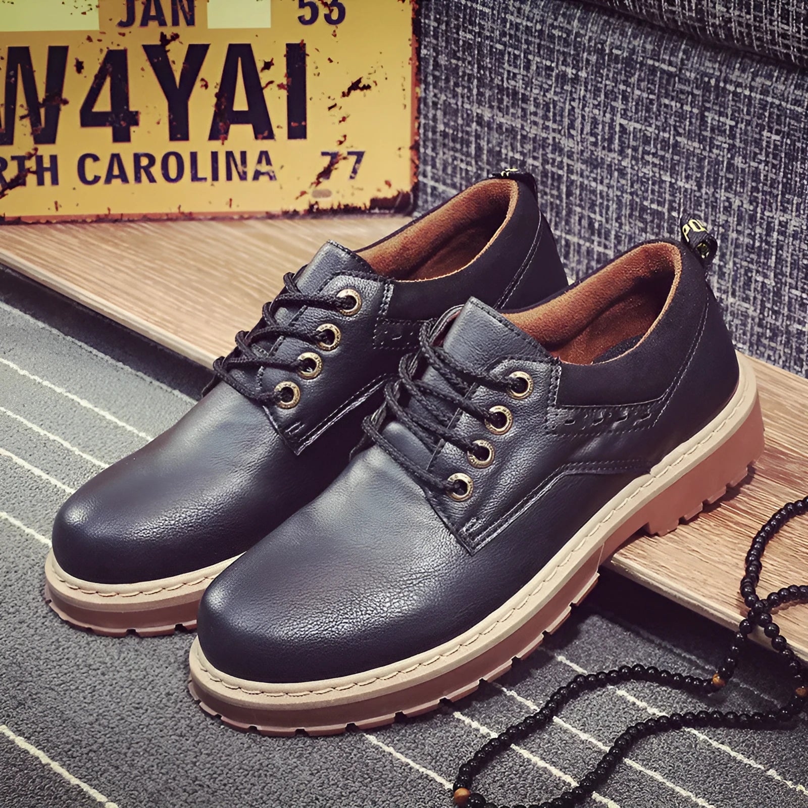 Men's black casual shoes with round toe, flat rubber sole, and front lace-up closure on a plain background.