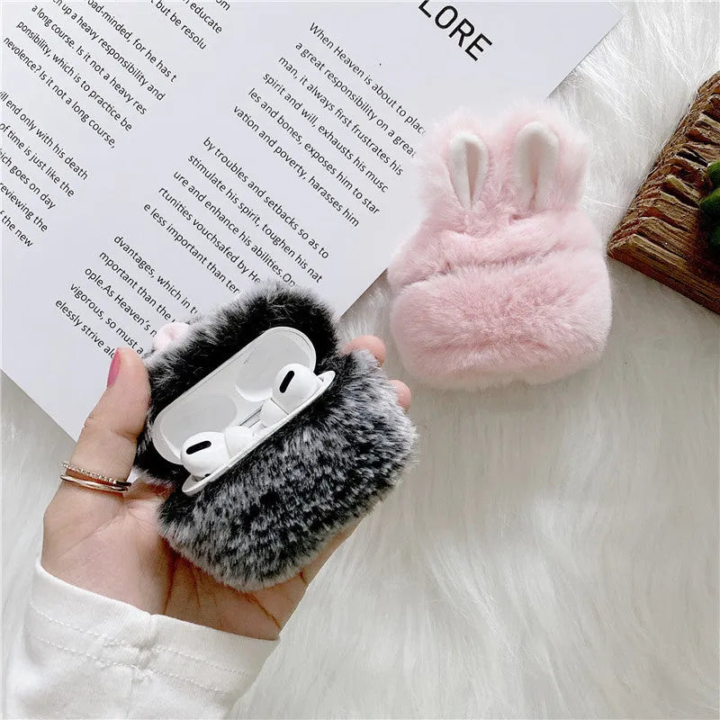 Soft pink silicone AirPods protective cover with rabbit ears design on a white earbud