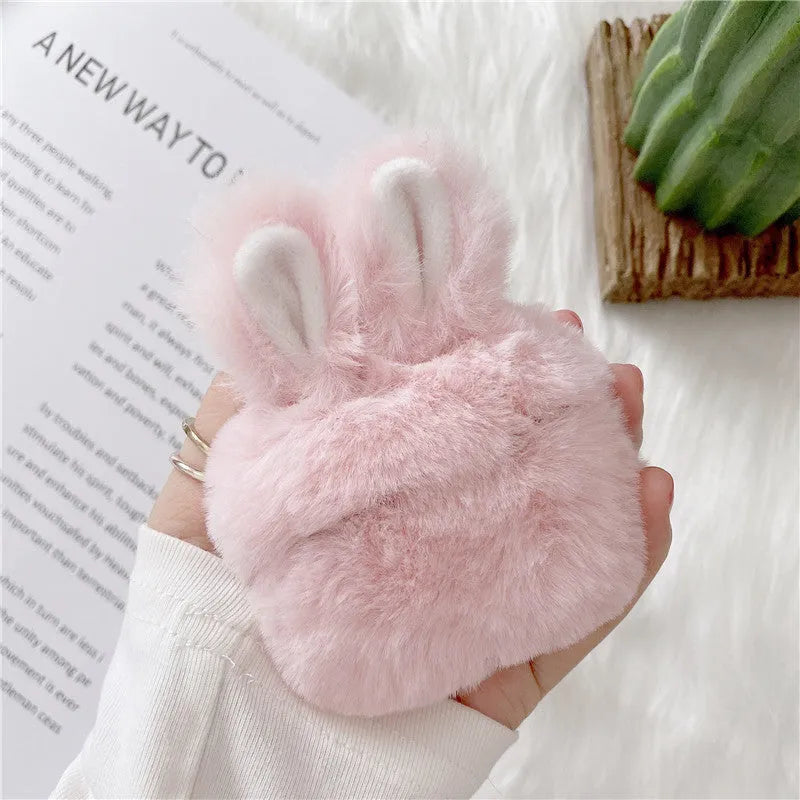Soft pink silicone AirPods protective cover with rabbit ears design on a white earbud