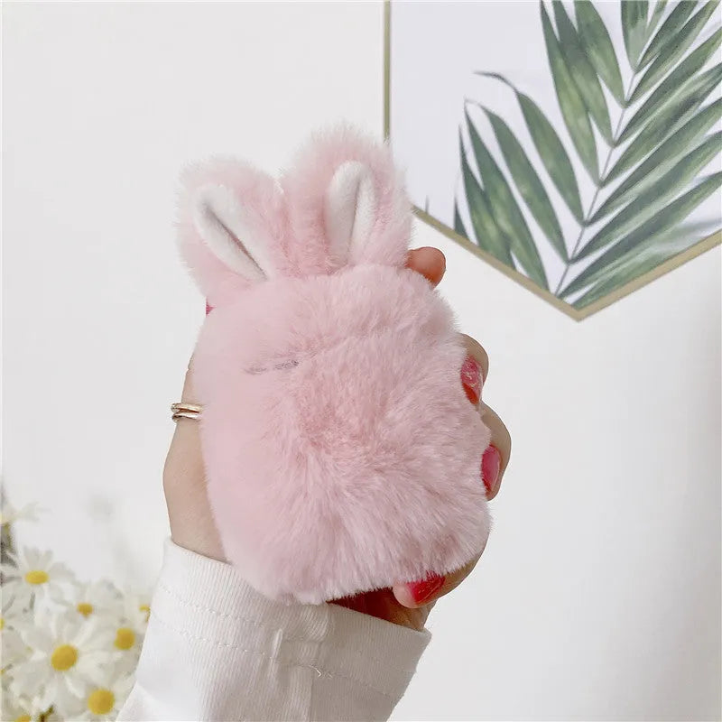 Soft pink silicone AirPods protective cover with rabbit ears design on a white earbud