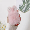 Soft pink silicone AirPods protective cover with rabbit ears design on a white earbud