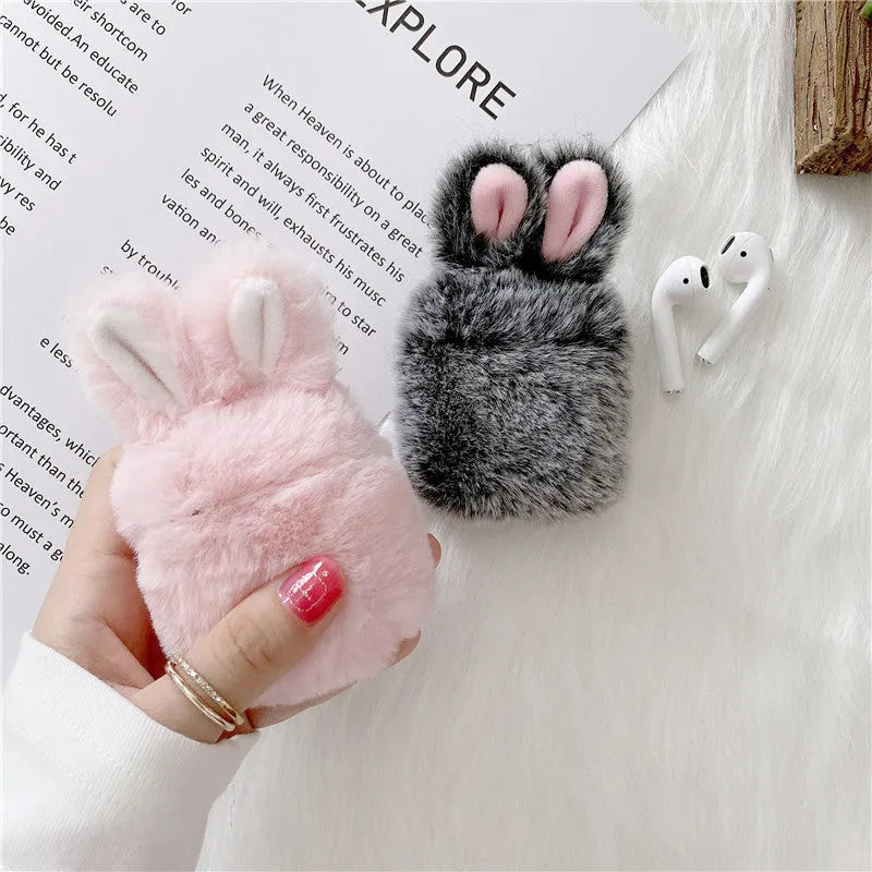 Soft pink silicone AirPods protective cover with rabbit ears design on a white earbud