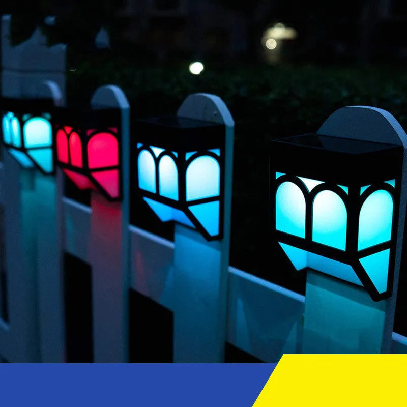 Square white solar-powered outdoor wall lamp with LED light, mounted on a fence post.