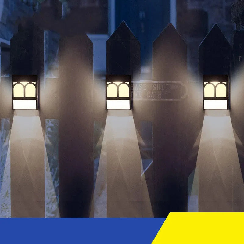 Square white solar-powered outdoor wall lamp with LED light, mounted on a fence post.