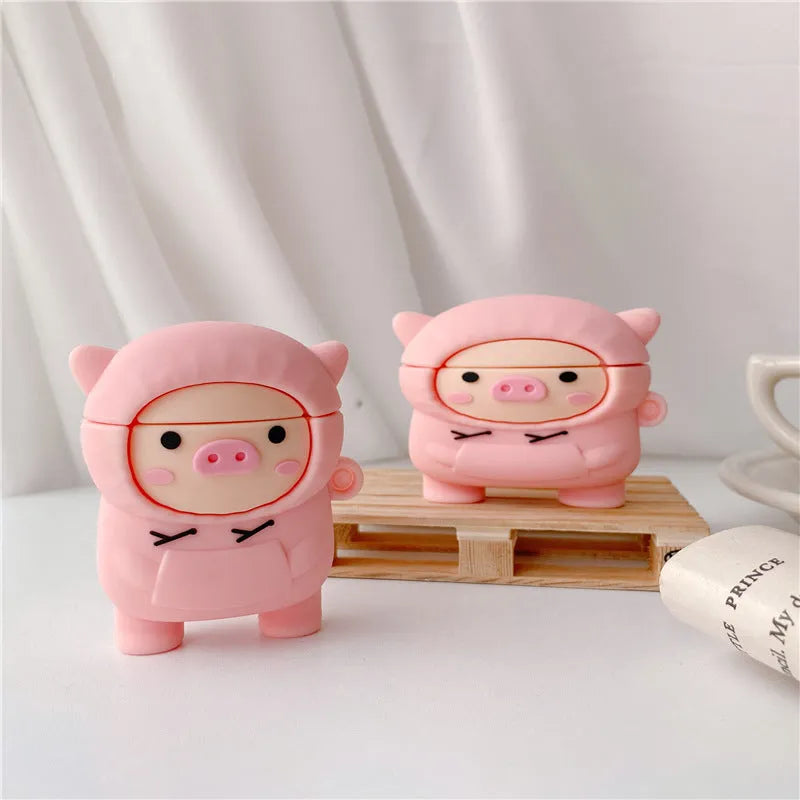 Soft pink silicone AirPods case cover with a cartoon pig graphic and a matching metal carry hook.