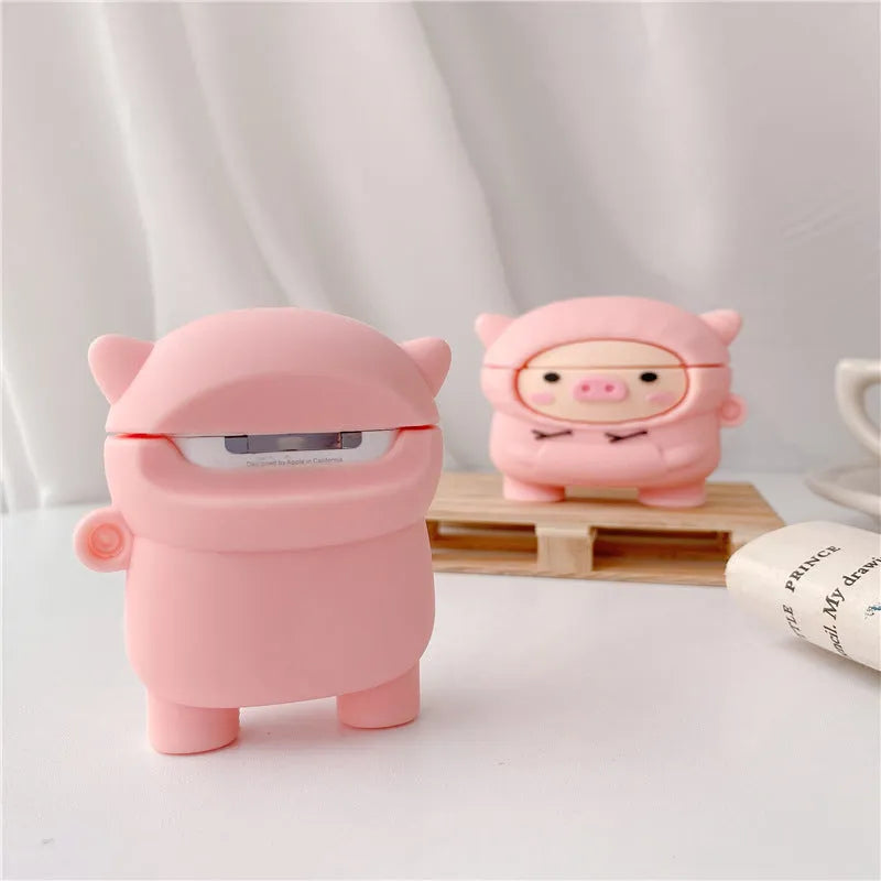 Soft pink silicone AirPods case cover with a cartoon pig graphic and a matching metal carry hook.