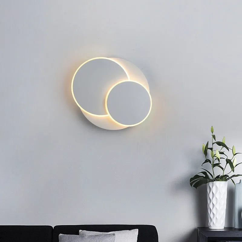Modern round wall lamp with acrylic shade in black or white finish, available in three sizes with LED lighting