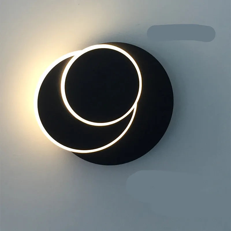 Modern round wall lamp with acrylic shade in black or white finish, available in three sizes with LED lighting