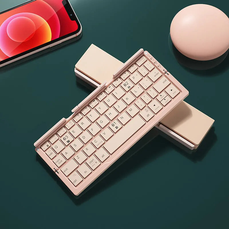 Silver aluminium folding Bluetooth keyboard open with smartphone propped on integrated stand