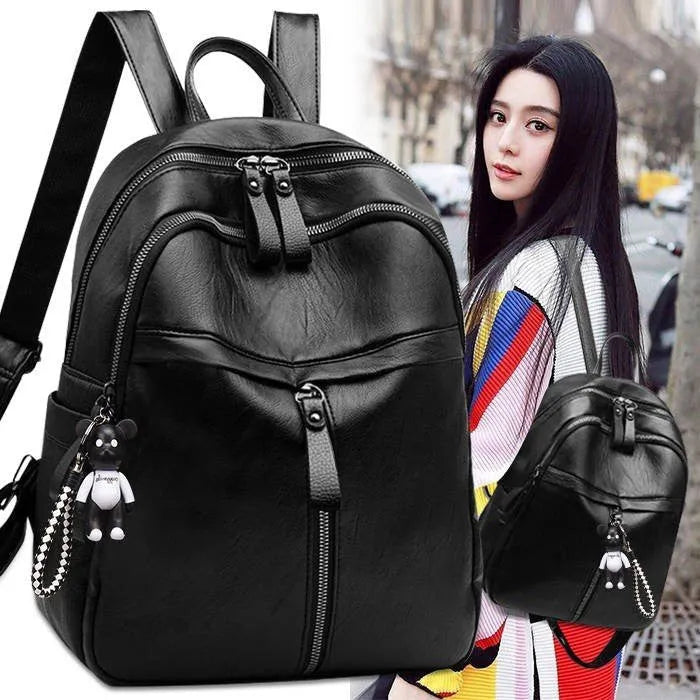 Black PU leather backpack with double shoulder straps showing luggage strap attachment
