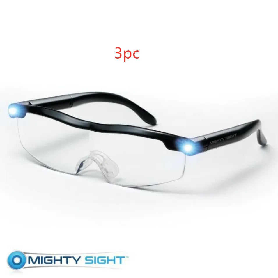 Transparent black USB LED reading light glasses with illuminated frames on a table.