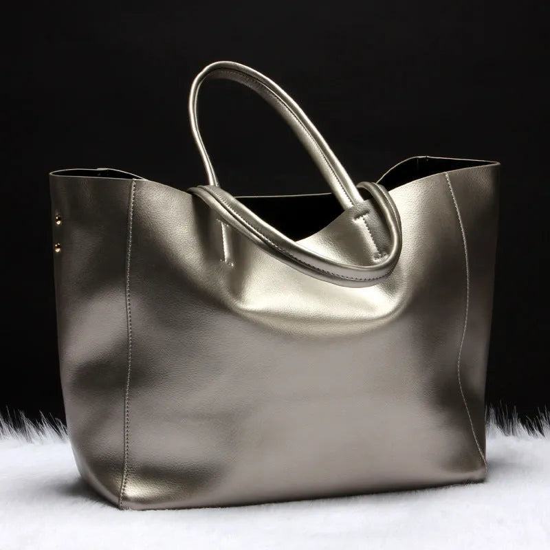 Women's cowhide leather shoulder bag in black with adjustable strap showing interior liner compartment