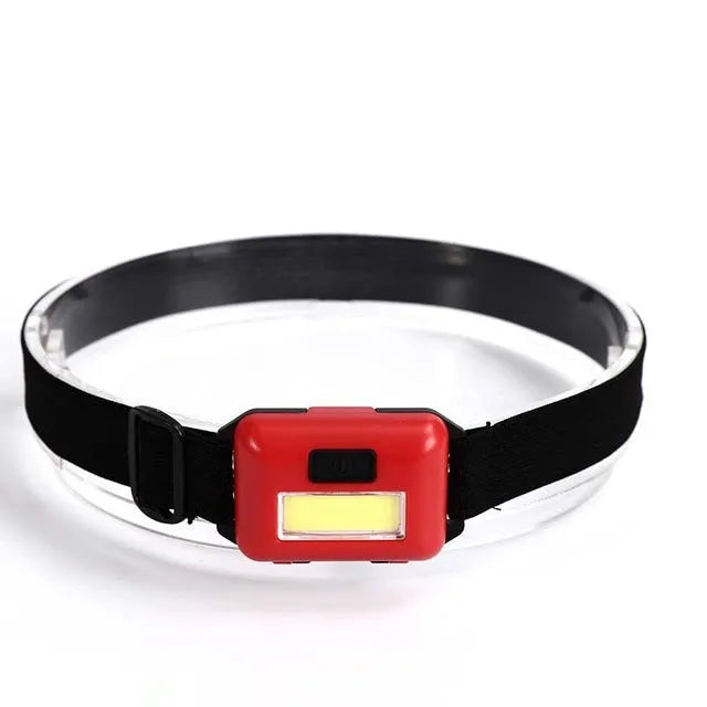 Compact blue, black, red, or white outdoor LED headlight with polyester head strap.