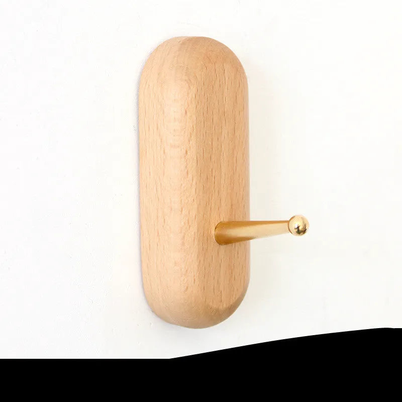 Beech wood adhesive wall hook with brass finish in capsule shape, shown next to round, oval, diamond and square variants.