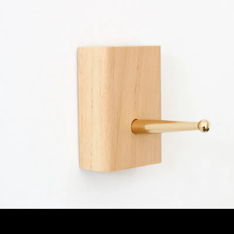 Beech wood adhesive wall hook with brass finish in capsule shape, shown next to round, oval, diamond and square variants.