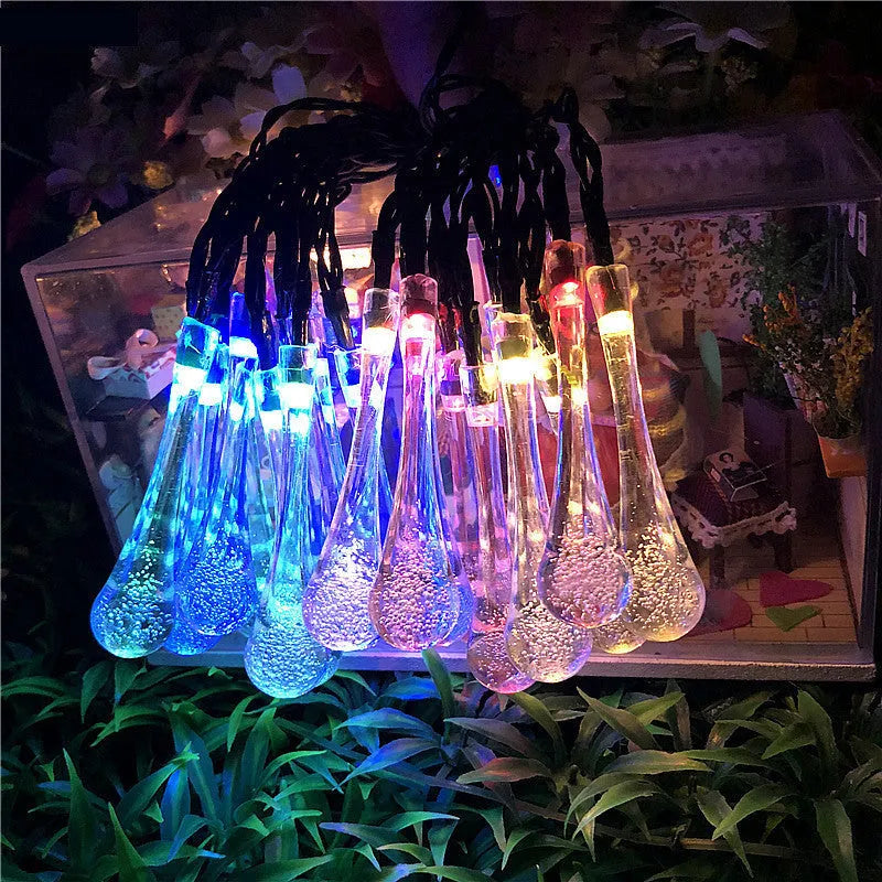 Solar-powered outdoor water drop LED string lights with warm white illumination on 6.5 metre waterproof cord