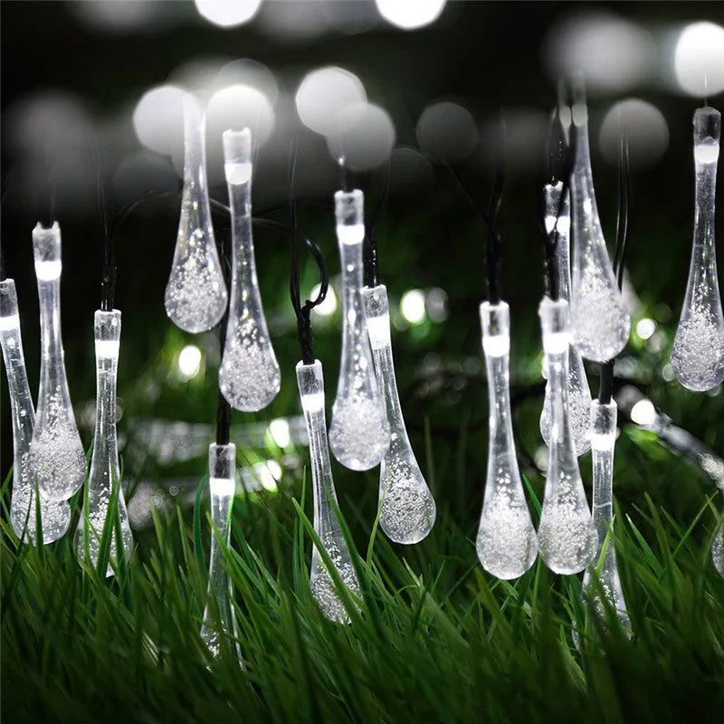 Solar-powered outdoor water drop LED string lights with warm white illumination on 6.5 metre waterproof cord