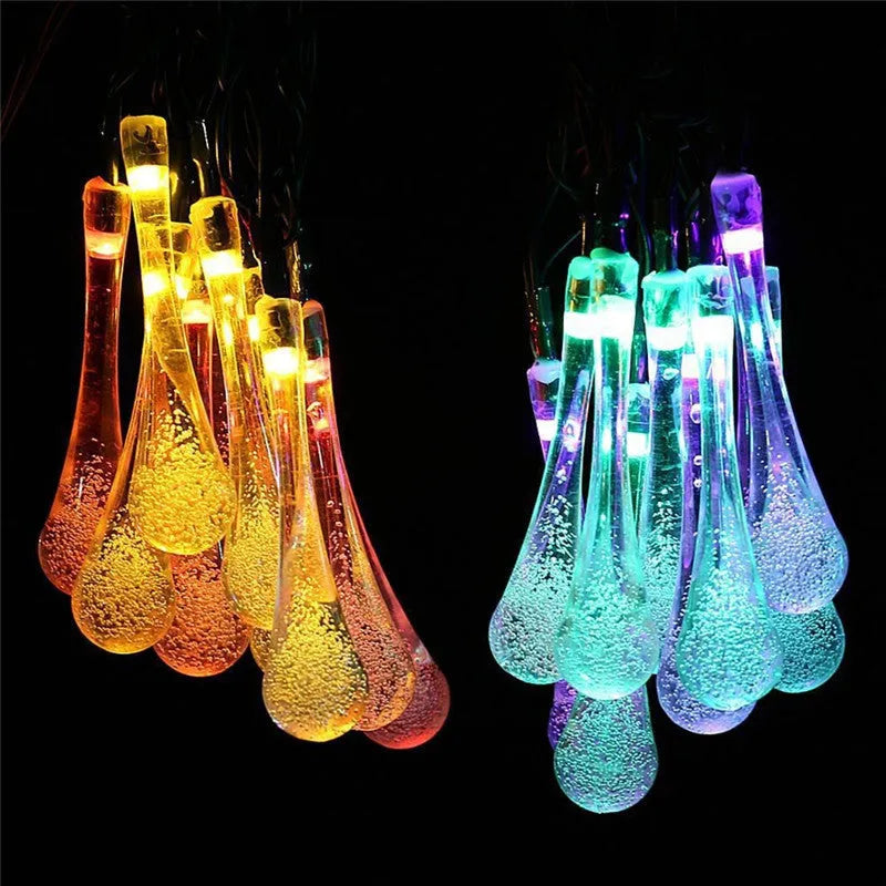 Solar-powered outdoor water drop LED string lights with warm white illumination on 6.5 metre waterproof cord