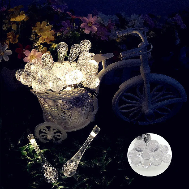 Solar-powered outdoor water drop LED string lights with warm white illumination on 6.5 metre waterproof cord