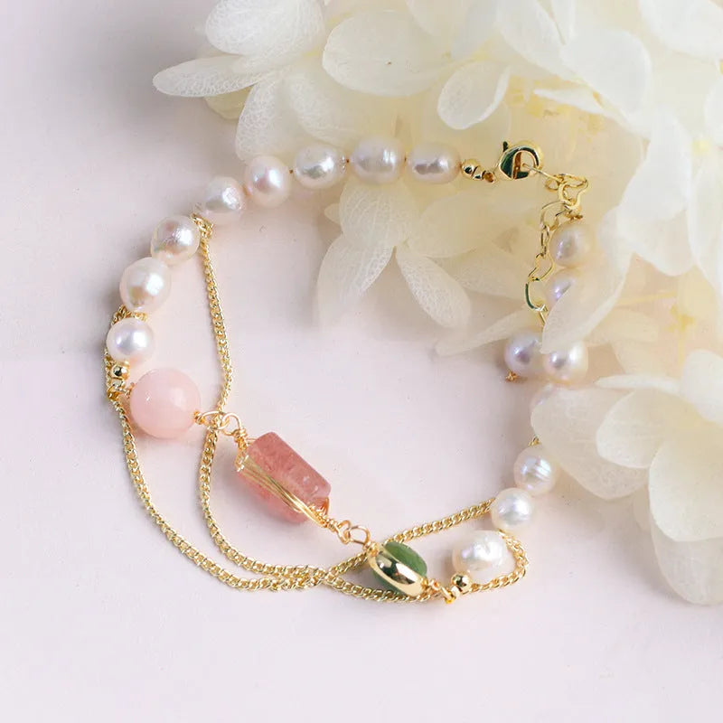 Pink freshwater pearl bracelet with geometric strawberry crystal charms on wrist