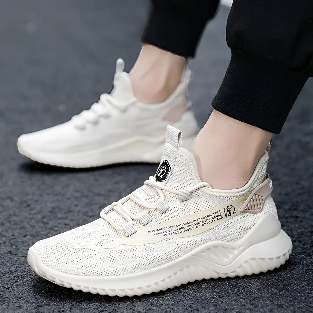 Men's white mesh sports trainers with round toe and rubber sole on neutral background