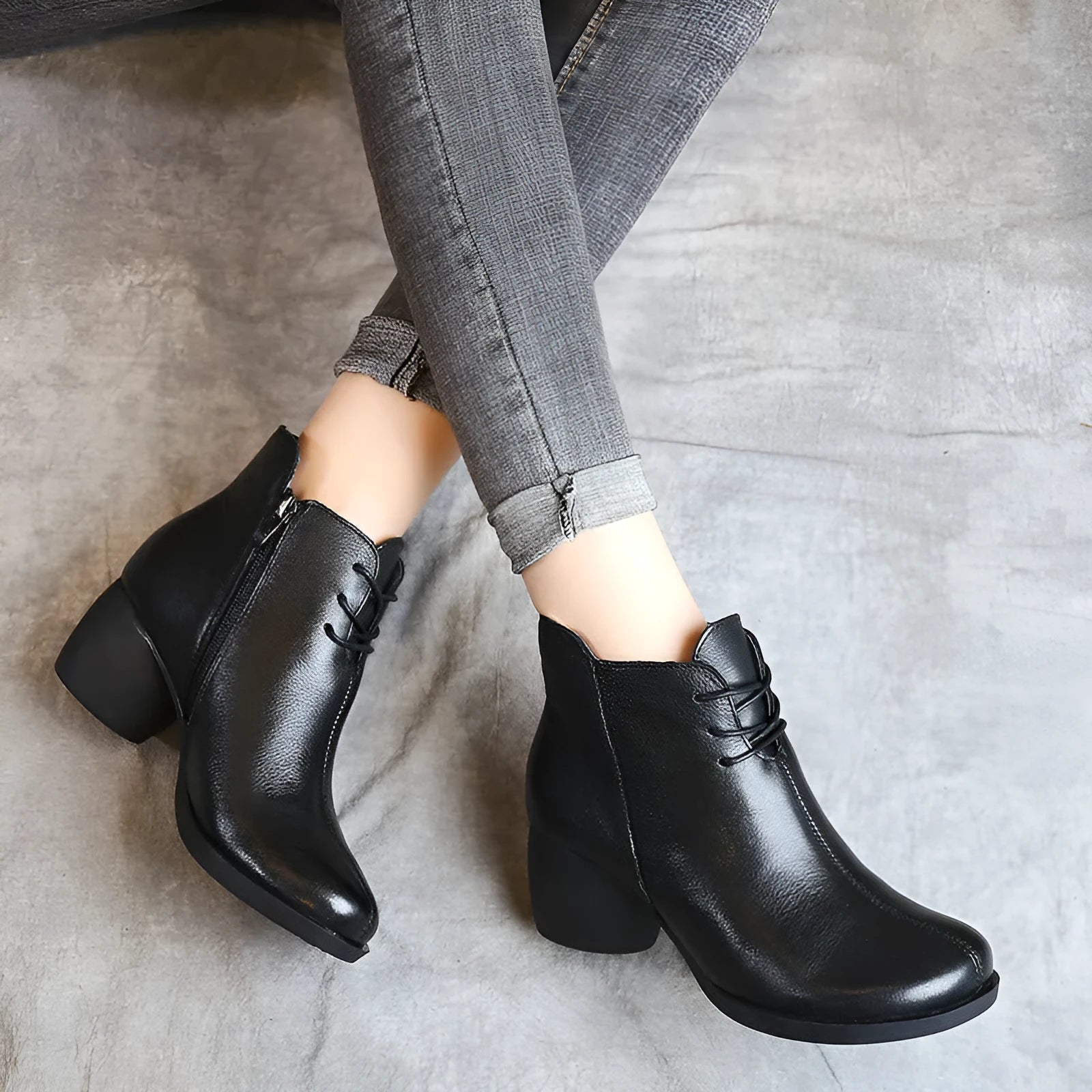 Women's black leather Martin boots with a thick middle heel and round toe on a white background.