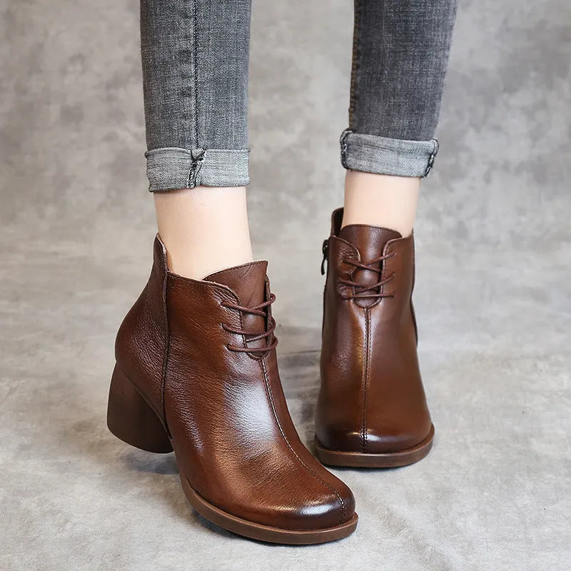 Women's black leather Martin boots with a thick middle heel and round toe on a white background.