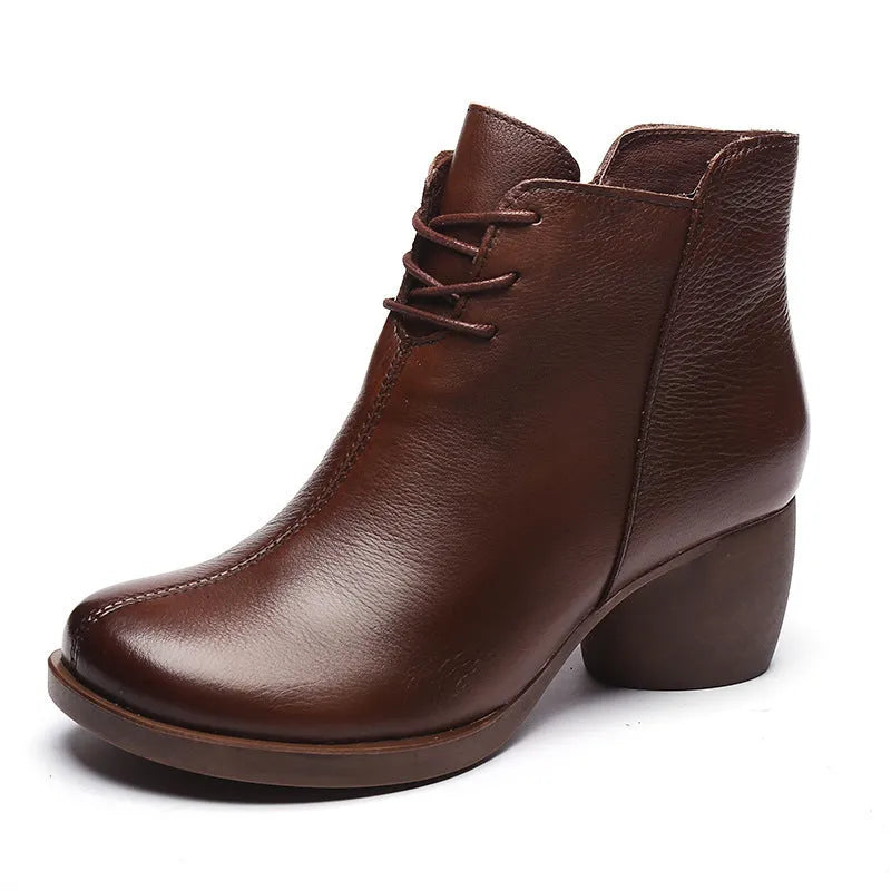 Women's black leather Martin boots with a thick middle heel and round toe on a white background.