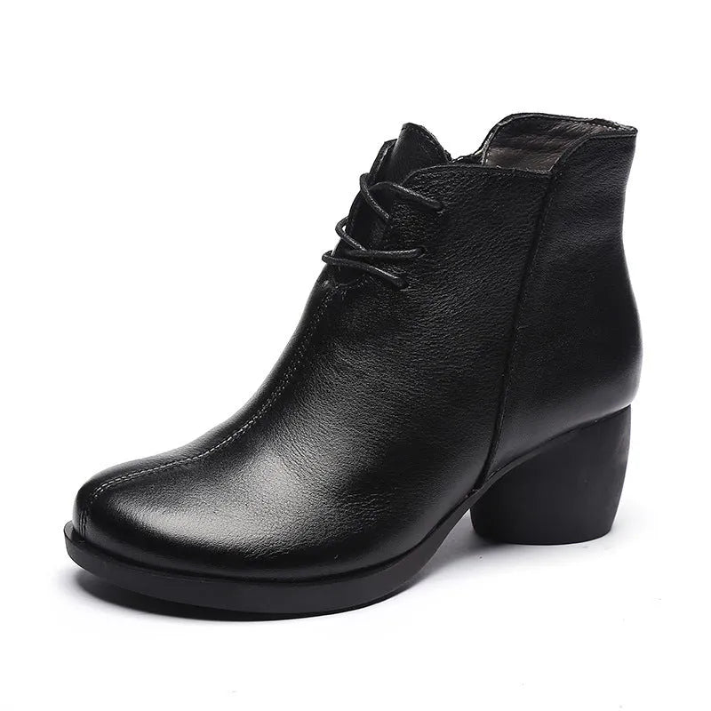 Women's black leather Martin boots with a thick middle heel and round toe on a white background.
