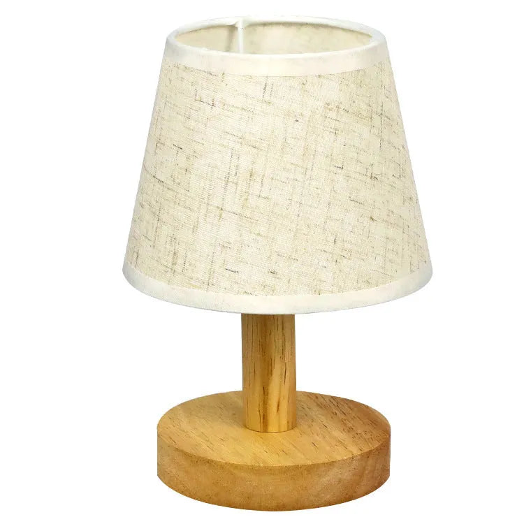 Vintage pleated table lamp with jute shade and bamboo base on a wooden table.
